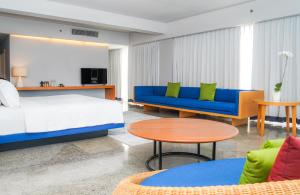 塞米亚克Cross Paasha Bali Seminyak的一间卧室配有一张床、一张沙发和一张桌子