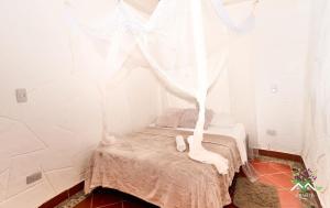 PepinoHostal Ariantiy的小房间,配有白色窗帘的床