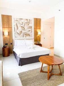 库塔Crystalkuta Hotel - Bali的一间卧室配有一张大床和一张桌子