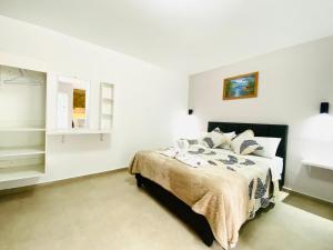 巴尼奥斯Casa Gaviota Dorada的一间白色客房内的床铺卧室