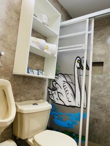 巴尼奥斯Casa Gaviota Dorada的浴室设有卫生间,墙上涂有天鹅
