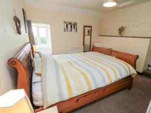 HawskerAbbey View Cottage的一间卧室配有带条纹毯子的床