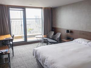 济州市Hotel With City的酒店客房设有一张床和一个大窗户