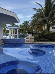 蒙特里科Agradable estancia en Monterrico的一个带蓝色瓷砖地板和棕榈树的游泳池