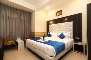 达兰萨拉Hotel Grand Nest的一间卧室配有一张带蓝色毯子的大床