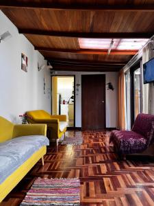 YanahuaraT'ikary Wasi Hostel的客厅配有沙发和椅子,铺有木地板