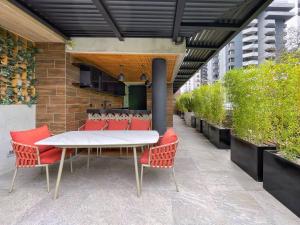 危地马拉Apartamento 1 Habitación, Edificio EON, Zona 10, Venecia的庭院配有白色桌子和红色椅子