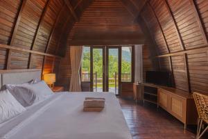 新加拉惹Munduk Kupang Sekumpul Villa的一间卧室配有一张大床和一台电视。