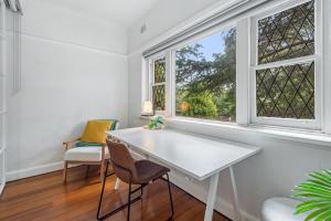墨尔本Elegant 1-Bed CBD Apartment with Sunroom Study的窗户客房内的白色桌椅