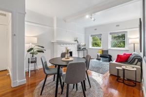 墨尔本Elegant 1-Bed CBD Apartment with Sunroom Study的用餐室以及带桌椅的起居室。