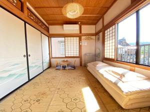 高山Guesthouse Takayama Hanzansha的一间卧室设有两张床和大窗户