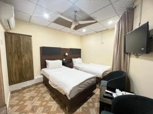 伊斯兰堡Islamabad Premium Hotel的一间酒店客房,设有两张床和电视