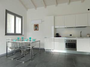 萨拉科马奇纳Acqua Dolce Comfortable holiday residence的厨房配有白色橱柜和桌椅