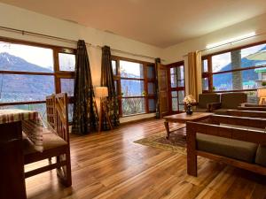 瓦皮Kamal Guest house的客厅设有大窗户和木地板