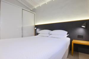 阿拉恰特AEGEAN Apartments - Bungalows的卧室配有一张带白色床单和枕头的大床。