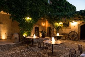 诺托玛丽娜Baglio Siciliamo Country House的庭院里设有桌椅,晚上则设有