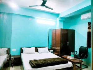 德奥加尔Hotel Ambika的一间拥有蓝色墙壁的卧室,配有一张床和一张桌子