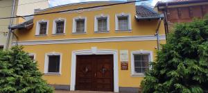 琼格拉德Hubertus Panzió的黄色的房子,设有棕色的门和窗户