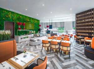 新加坡Hotel Mi Rochor的一间带桌椅和绿色墙壁的餐厅