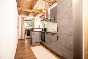 齐勒谷地施特拉斯Apartment in Strass im Zillertal in a beautiful setting的厨房配有不锈钢用具和木制天花板。