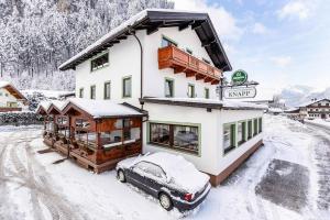 齐勒谷地施特拉斯Apartment in Strass im Zillertal in a beautiful setting的雪中停放汽车的房子