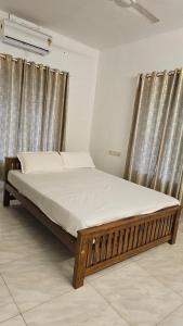 德里久尔Peaceful homes的一张带窗帘的房间里的床