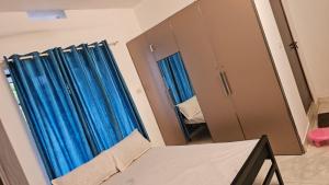 德里久尔Peaceful homes的一间卧室配有蓝色窗帘和镜子