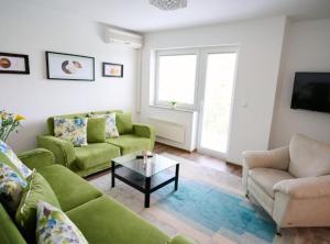 萨拉热窝Villa R的客厅配有绿色沙发和咖啡桌