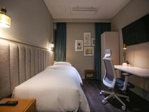 首尔Hotel Crescendo Seoul的配有一张床和一张书桌的酒店客房