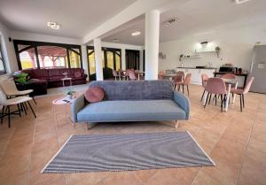 凯斯特海伊Nussbaum Panzió的一间带蓝色沙发的客厅和一间厨房