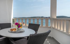 特罗吉尔Villa Ana Trogir II的阳台上摆放着一盘食物和鲜花的桌子