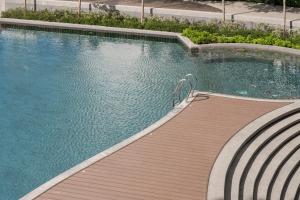 哥打京那巴鲁Citadines Waterfront Kota Kinabalu的一座大型游泳池,设有木制走道