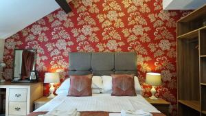 康威George & Dragon, Conwy的一间卧室配有一张红色墙壁的床