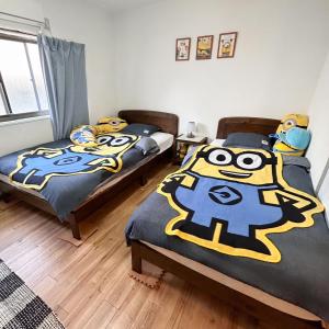 大阪林林の民宿-関空直達、minion room 小黄人主题房的一间卧室配有两张带面罩的床