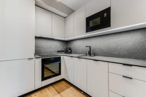 塔林15 korruse premium katusekorter的白色的厨房配有白色橱柜和水槽
