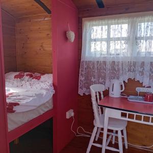 Saint IshmaelsCoast path camping的一间卧室配有一张床、一张桌子和一个窗户。