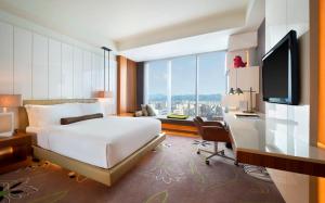 台北台北 W 酒店 的酒店客房配有一张床、一张书桌和一台电视。