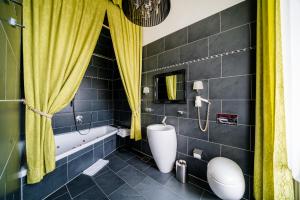维也纳戈登斯宾酒店 的带浴缸、卫生间和黄色窗帘的浴室