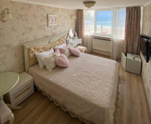 敖德萨萨兰达酒店的一间卧室配有带粉红色枕头的床和窗户。