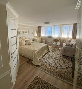 敖德萨萨兰达酒店的一间卧室配有一张床、一张沙发和一个窗口
