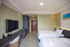 科罗尔Belmond Hotel 贝尔曼酒店的酒店客房设有两张床和一台平面电视。