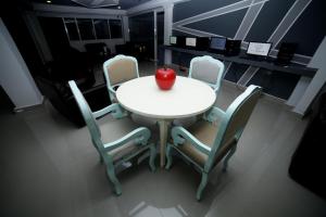 巴兰基亚Hotel San Marcos Barranquilla的一张带四把椅子的白色桌子和苹果
