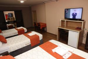 阿达纳阿达纳萨拉伊酒店的一间酒店客房,设有三张床和一台平面电视
