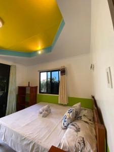 锡基霍尔Residencia Gemma的一间卧室设有一张黄色天花板的大床