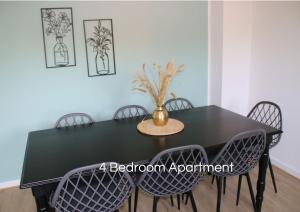 HauCozy Apartment in Bedburg-Hau的一张黑色餐桌,上面有椅子和花瓶