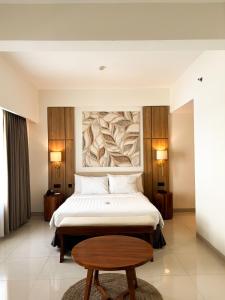 库塔Crystalkuta Hotel - Bali的酒店客房配有一张床铺和一张桌子。