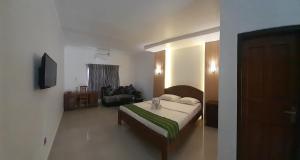 纳闽巴霍普伦迪绿色酒店的一间卧室设有一张床和一间客厅。