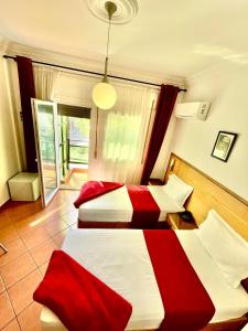 米迪克Sary's Hotel的红色和白色的客房内的两张床