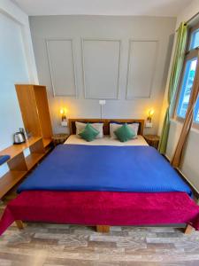 比尔瓦The Trippy Tribe的一间卧室配有一张带蓝色毯子的大床