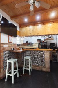 罗塔Hostal Restaurante La Giralda的厨房配有2张凳子和1个柜台